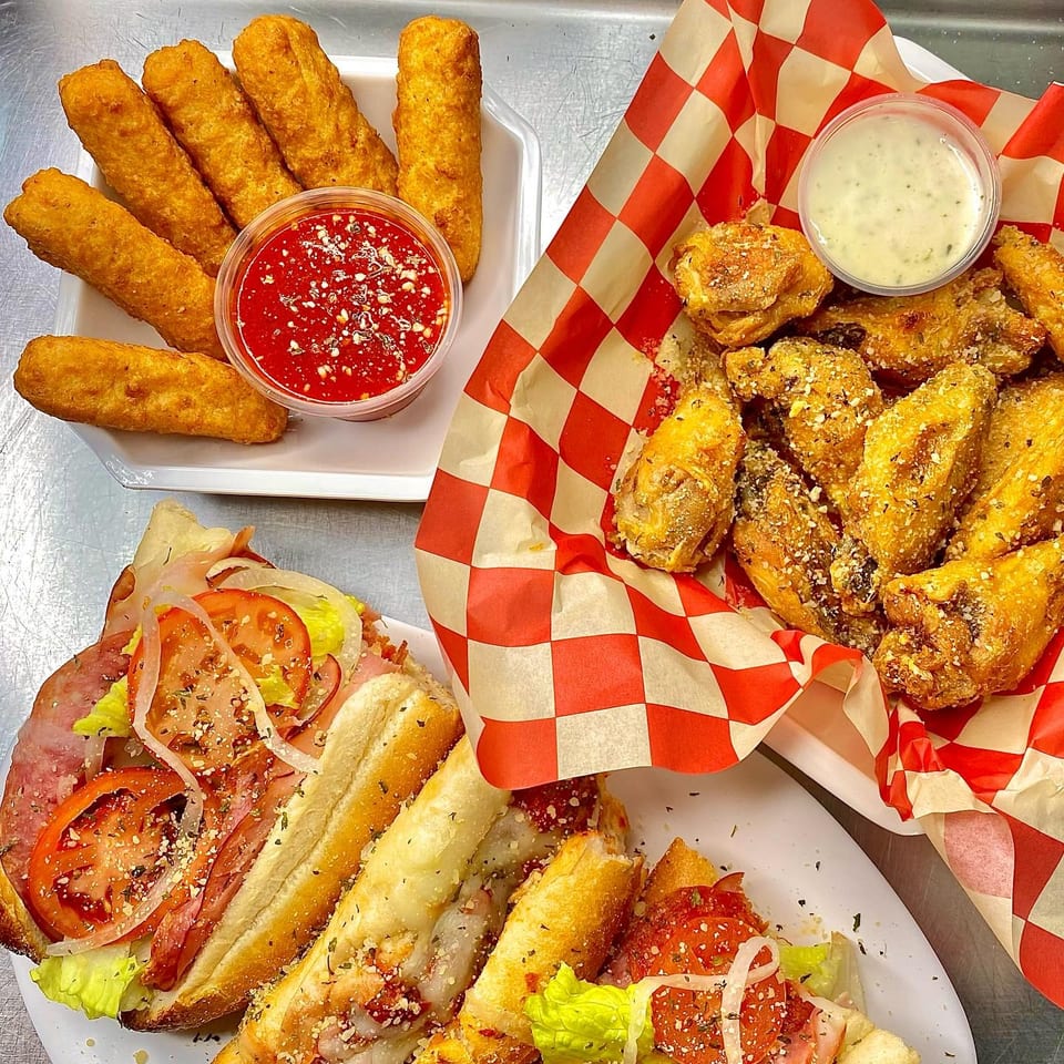 Mozzarella sticks with marinara, garlic parmesan wings, and two Italian subs with toppings.